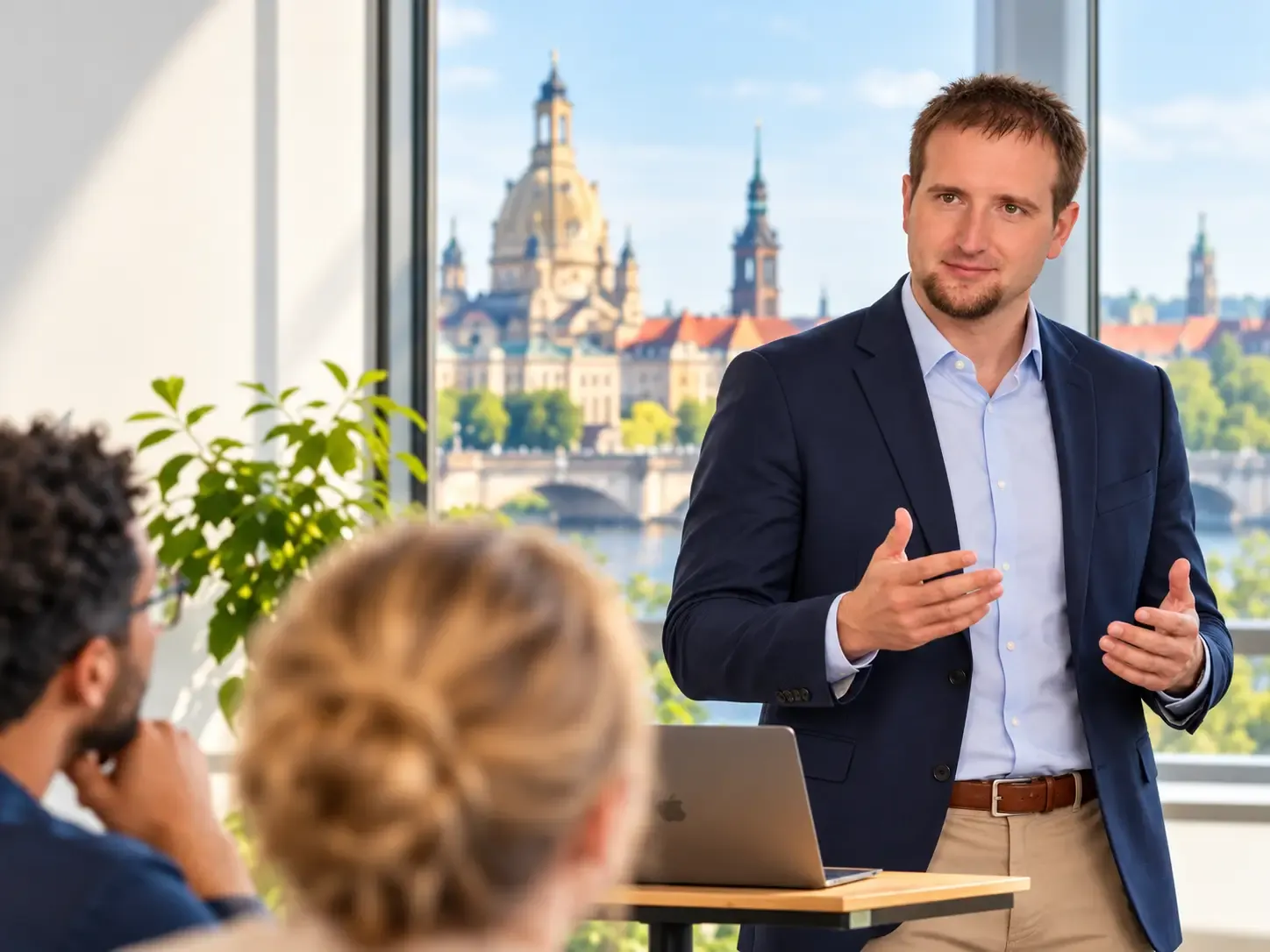 Stefan Ullmann präsentiert einem Team in einem Büro, im Fenster die Dresdner Frauenkirche